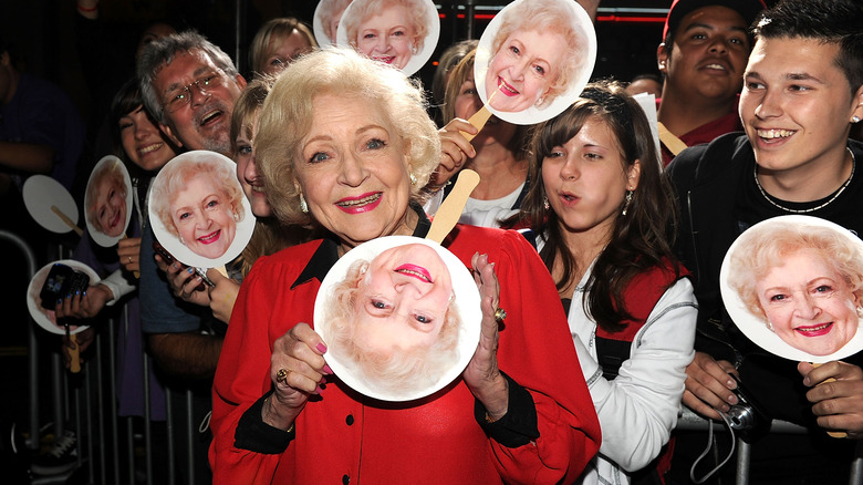 Betty White holding signs of her face