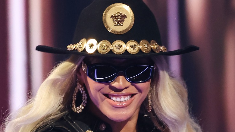 Beyonce smiling in sunglasses and cowboy hat