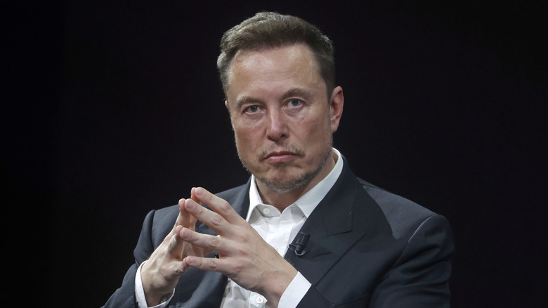 Elon Musk in front of a black background while attending a conference