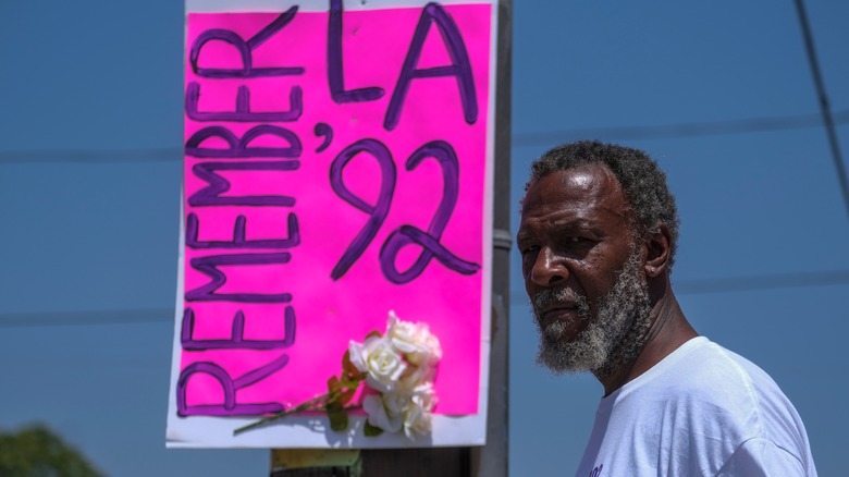 Man near LA riots sign