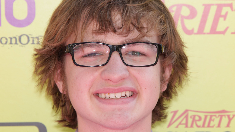 Angus T. Jones smiling glasses at event