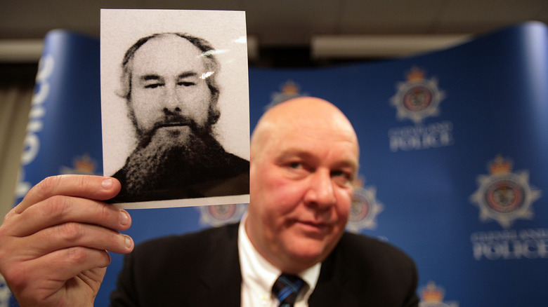 officer holding photo of John Darwin