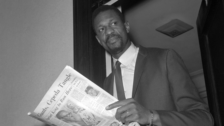 Bill Russell holding newspaper