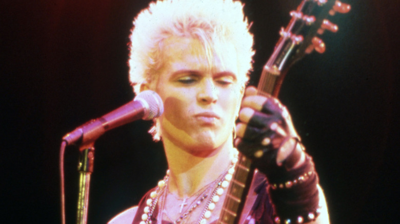 Billy Idol on stage playing guitar before microphone