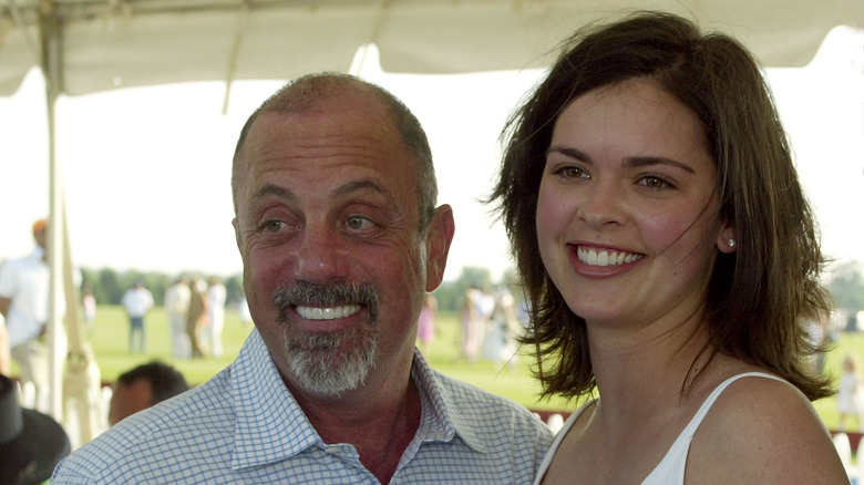 Billy Joel smiling with Katie Lee