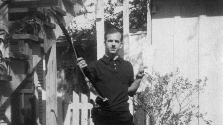 Lee Harvey Oswald holds gun backyard