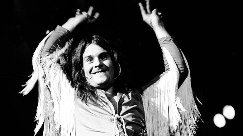 Ozzy Osbourne throws his hands up