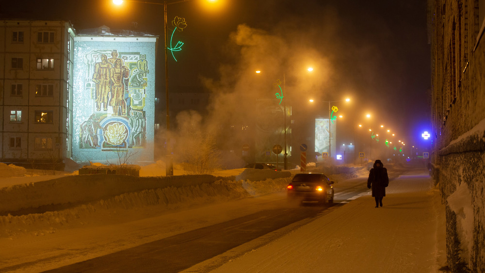 A snowy empty street in Russia with person on sidewalk