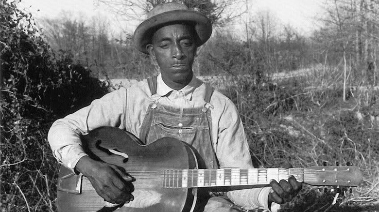 Mississippi Fred McDowell holding guitar