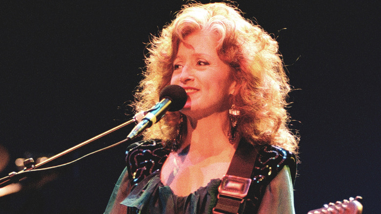 Bonnie Raitt with guitar and microphone