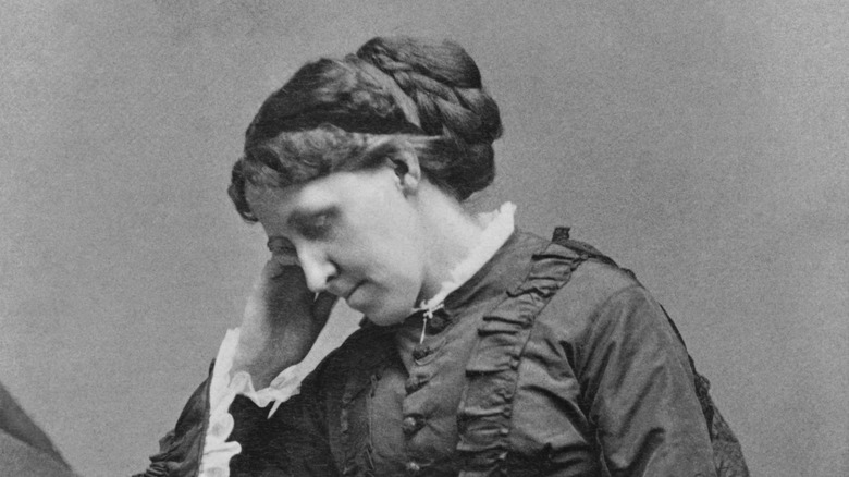 Louisa May Alcott writing at desk