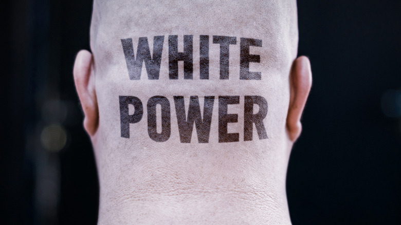 shaved head with "white power" written