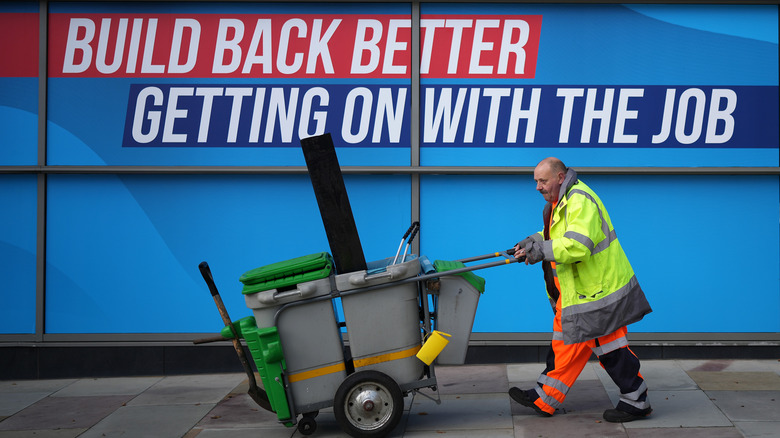 Cleanup man walking past conservative party sign