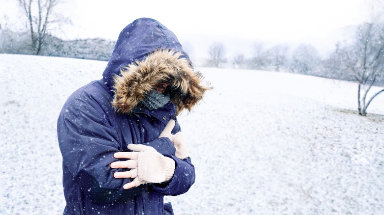 man outside in the snow bundled up