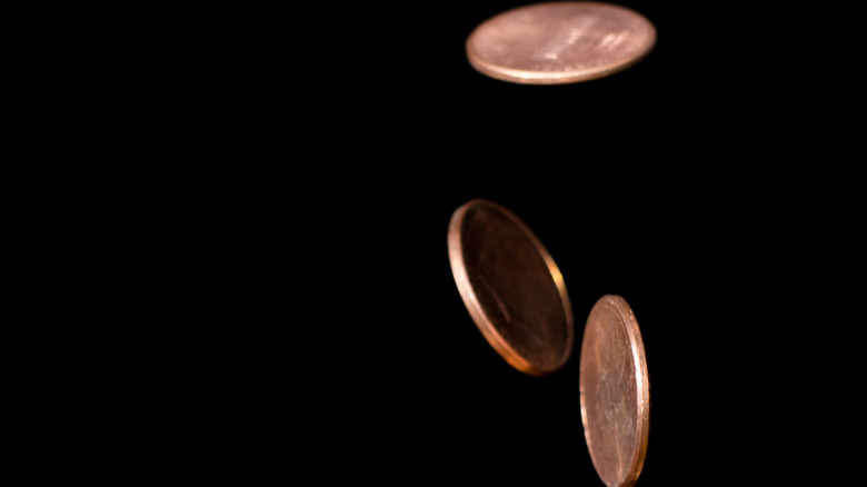 Coins falling against black background