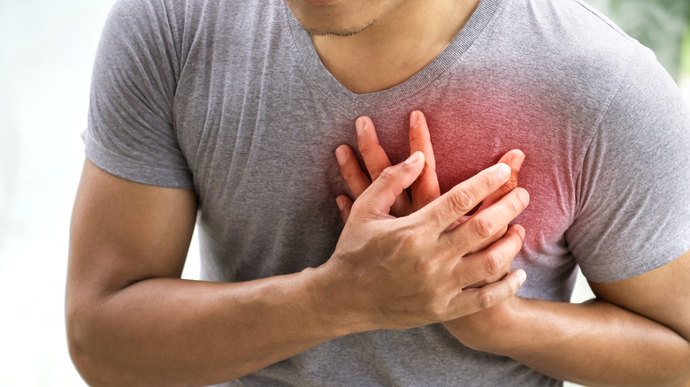 man with hands to chest