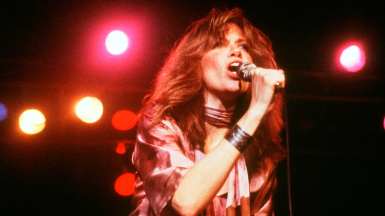 Carly Simon holding microphone red lights