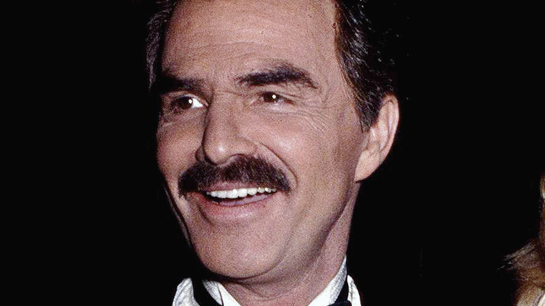 Burt Reynolds wearing a tux and smiling