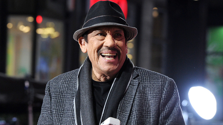 Danny Trejo hat suit smiling at parade