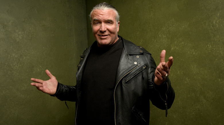 Scott Hall smiling arms raised black leather jacket