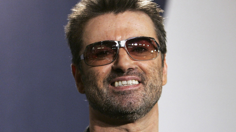 George Michael in sunglasses smiling