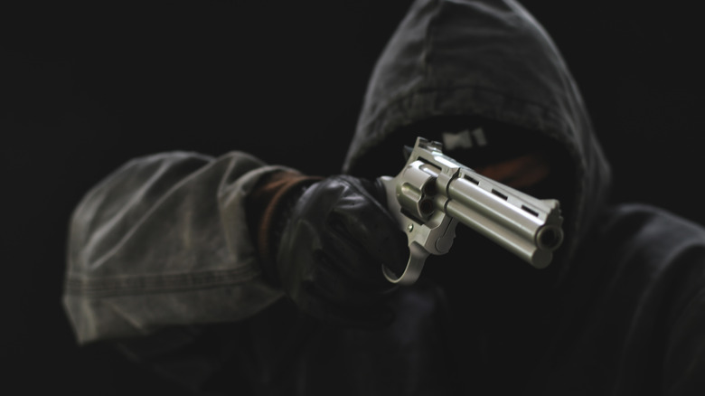 Man black hoodie brandishing gun