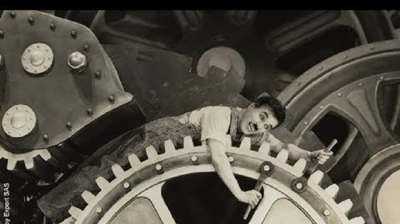 charlie chaplin laying on large gear