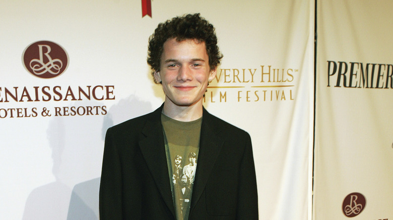 Anton Yelchin posing on a red carpet at the Beverly Hills Film Festival