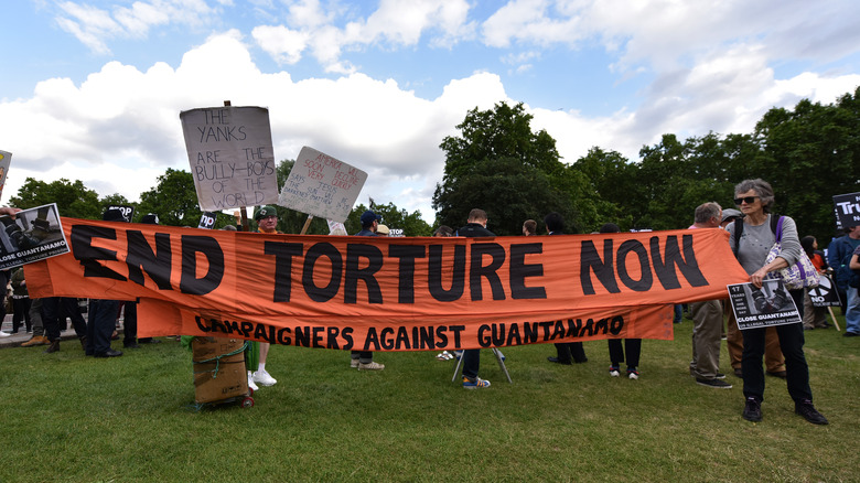 Activists protest with end torture sign