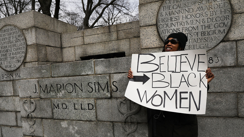 Protestor at J Marion Sims statue