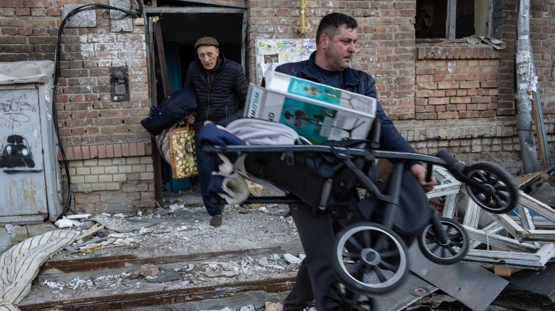 Man carrying rubble from building