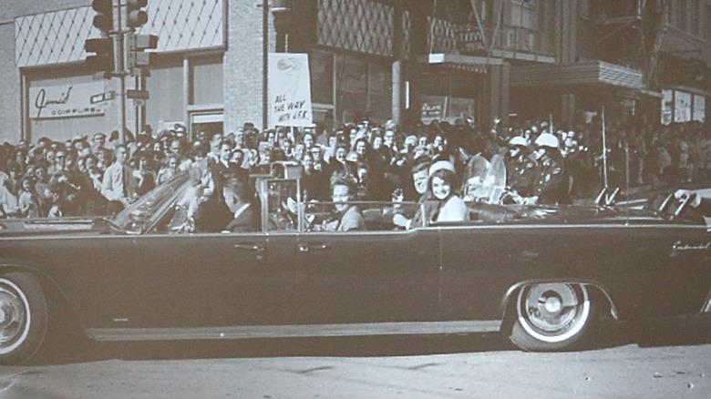 Clint Hill riding on JFK's limo by crowd