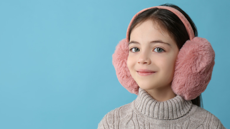 Person wearing earmuffs and thick jumper