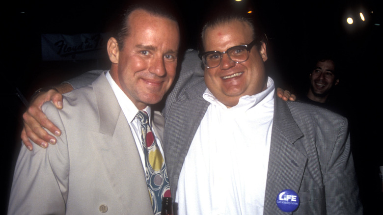 Phil Hartman and Chris Farley suits smiling hugging