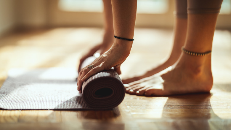 A woman rolling out a yoga mat