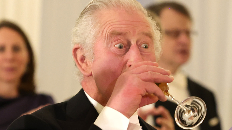 King Charles III drinking Champagne