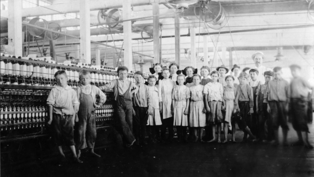 Children working in a factory loom around 1910