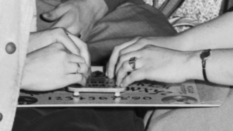 Two young women play with a Ouija board