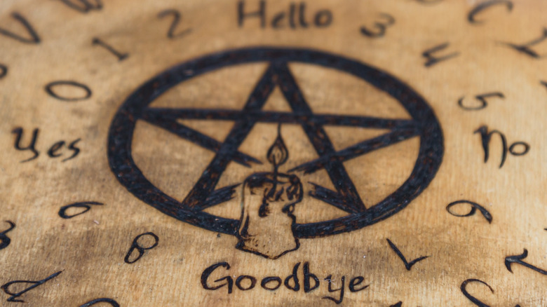 A pentagram decorates a modified Ouija board