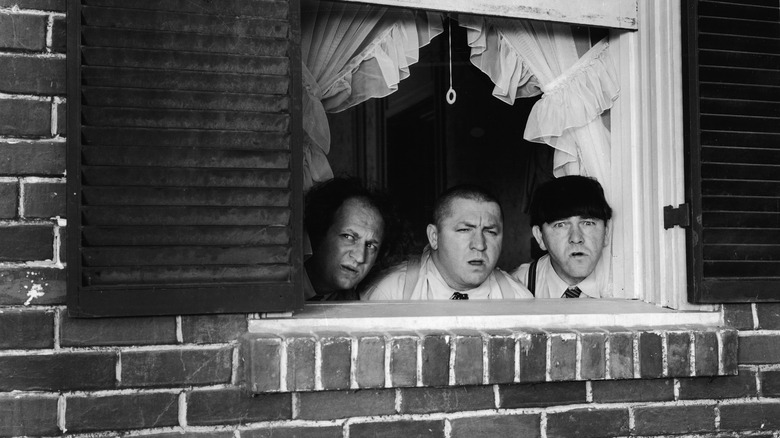 Three Stooges peering out a window