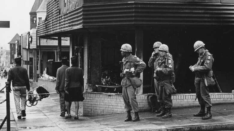 National Guardsmen in front of burnt building