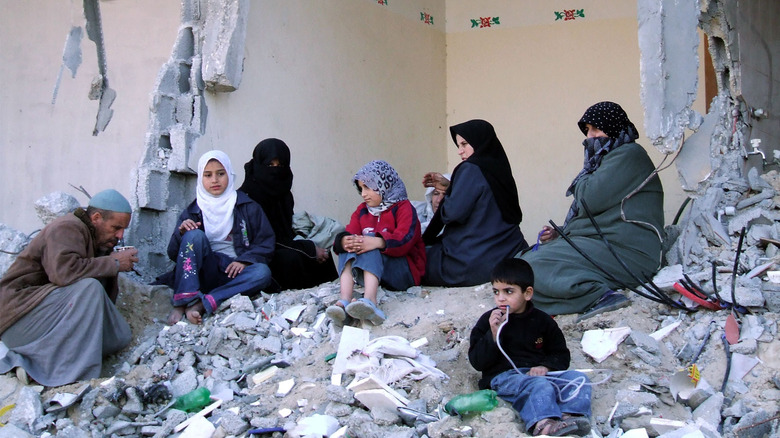 Palestinians sitting in their destroyed home in Gaza.