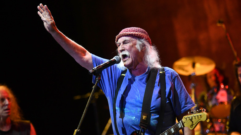 David Crosby raising hand to crowd