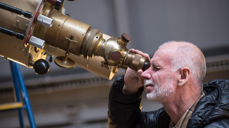  man looking through telescope