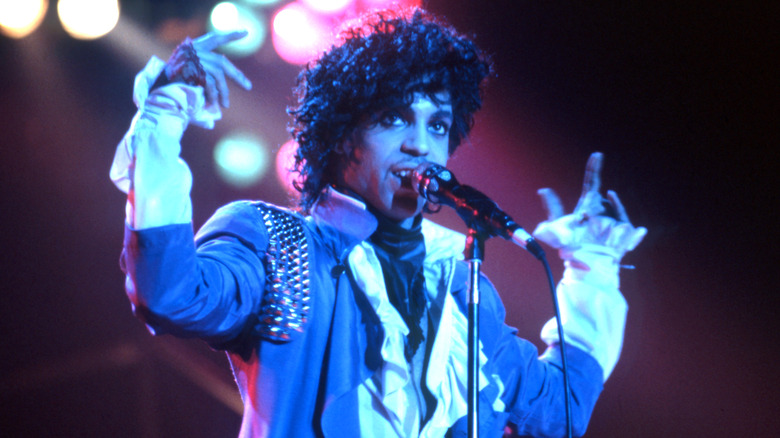 Prince purple top gesturing singing on stage