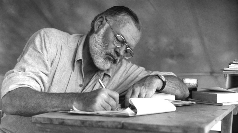 Ernest Hemingway writing with pencil