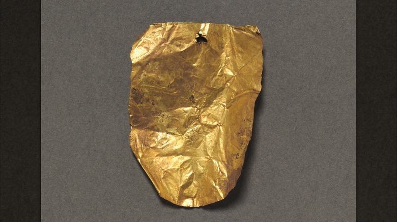 Crumpled sheet of gold tongue-shaped