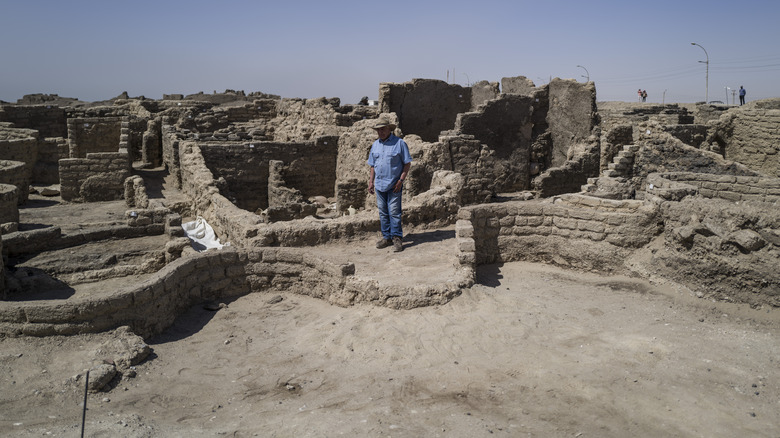 Archeological site low ruins man in denim and hat