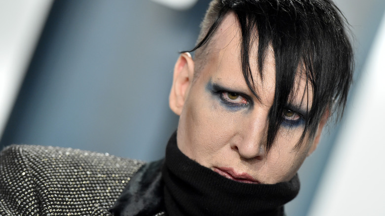 Marilyn Manson frowning in blue eyeshadow