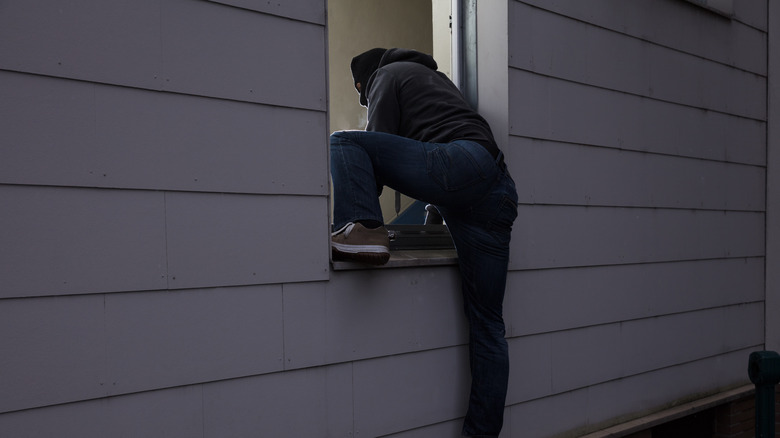 Man climbing in window balaclava 